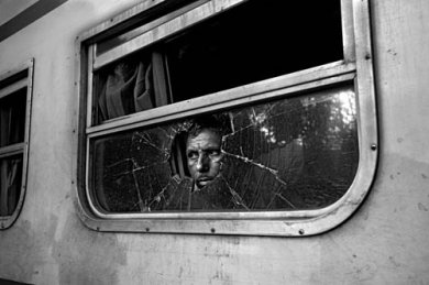 © Gaël TURINE - Bangladesh. Derrière la vitre brisée du train qui longe la frontière sur quelques kilomètres dans la région de Hakimpur, un passager attend son contact local qui lui remettra des produits indiens de contrebande.