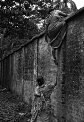 © Gaël TURINE - Inde. Entre deux patrouilles de la Border Security Force, des Bangladaises descendent du mur de séparation qu'elles ont escaladé de l'autre côté. Elles arrivent les mains vides mais repartiront chargées de produits de contrebande